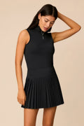 Black | Woman wearing a black colored pleated skirt on a beige background