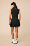 Black | Woman wearing a black colored pleated skirt on a beige background