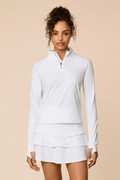 White | Woman wearing a white colored outfit with a Lexi polo shirt and Tulip skort on a beige background