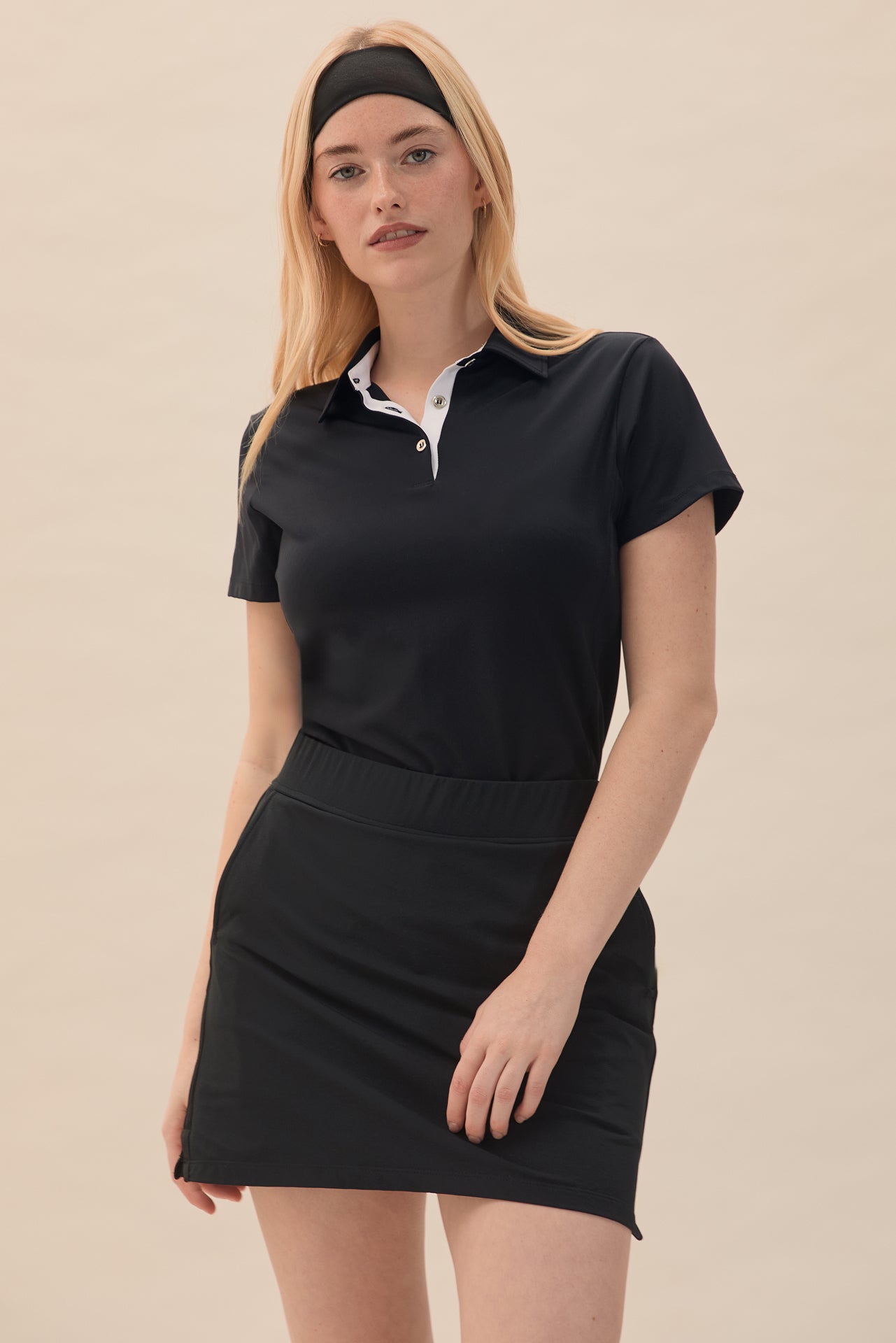 Black | A mid-waist black skort with integrated moisture-wicking knit short, designed for golf ball storage and tee holders.