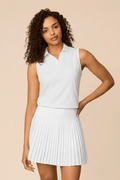 White | Woman wearing a white colored pleated skirt on a beige background