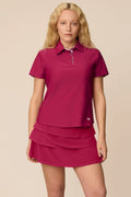 Aurora | Woman wearing the Aurora colored Lexi Polo and tulip skort on a beige background