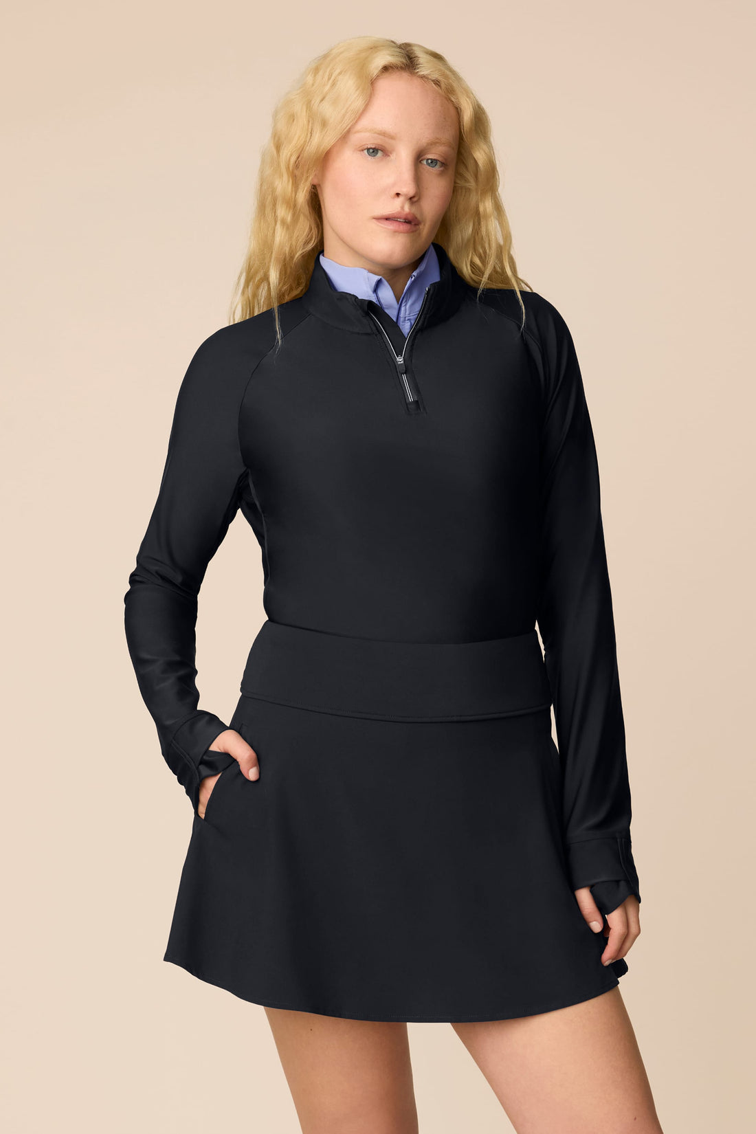 Midnight | Woman wearing a Midnight Taylor Long-Sleeve Half-Zip and skort on a beige background
