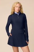 Midnight | Woman wearing a Midnight Taylor Long-Sleeve Half-Zip and skort on a beige background