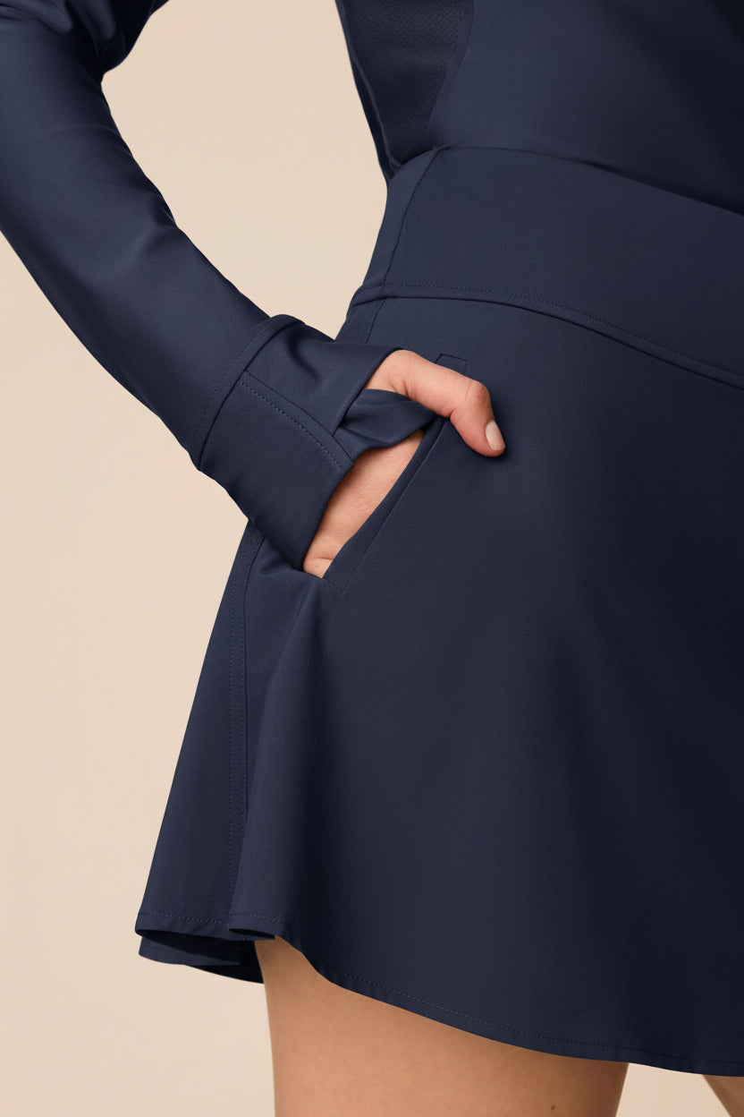 Midnight | Woman wearing a Midnight Taylor Long-Sleeve Half-Zip and skort on a beige background