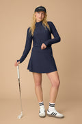 Midnight | Woman wearing a Midnight Taylor Long-Sleeve Half-Zip and skort on a beige background