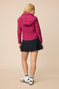 Aurora | Model wearing a hooded Aurora colored Gabrielle windbreaker with skort.