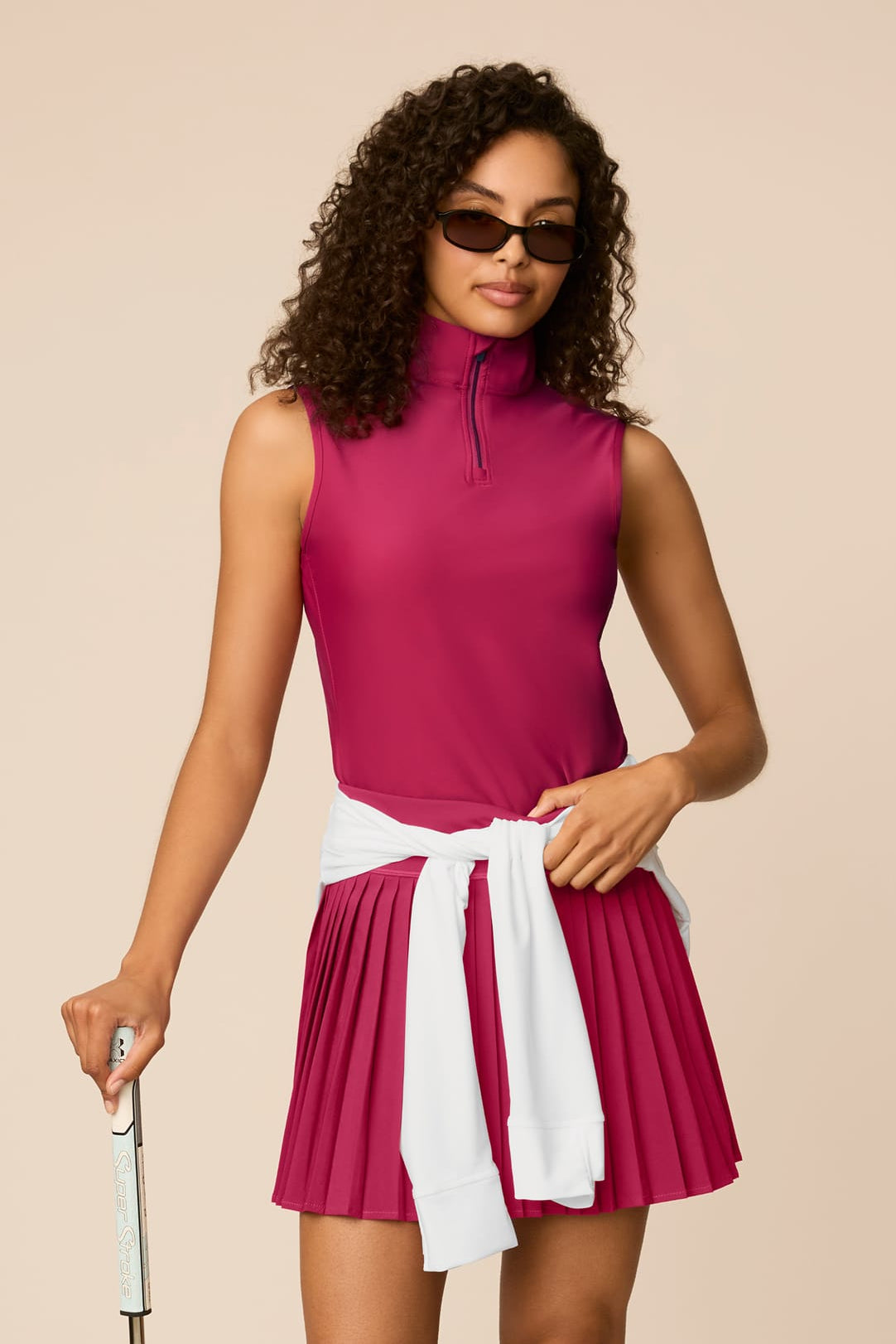 Aurora | Woman wearing The Michelle Pleated Skort 15" pleated skirt on a beige background