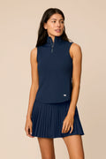 Midnight | Woman wearing a midnight sleeveless top and pleated skort on a beige background
