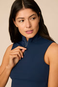 Midnight | Woman wearing a midnight sleeveless top and pleated skort on a beige background