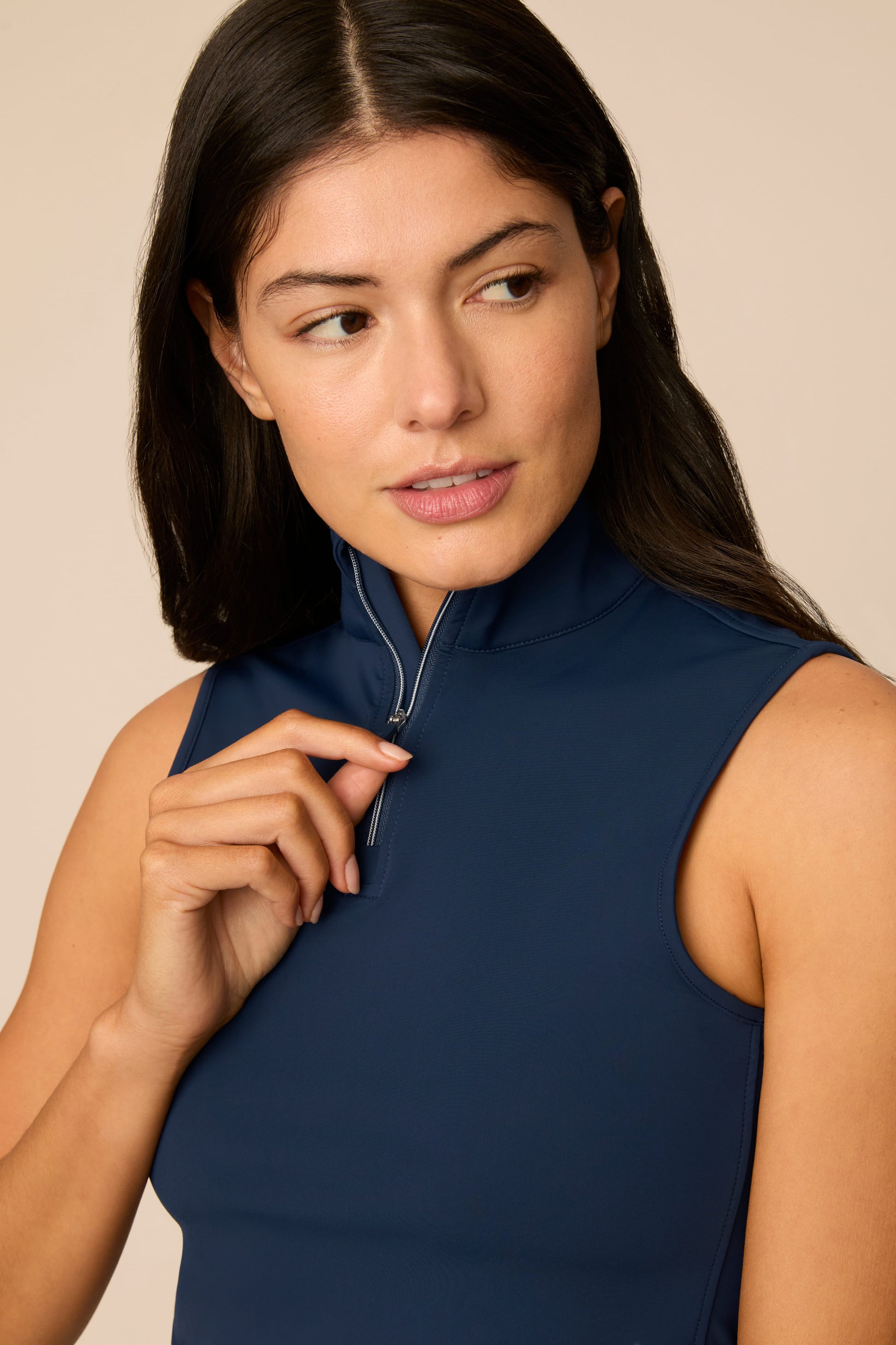 Midnight | Woman wearing a midnight sleeveless top and pleated skort on a beige background