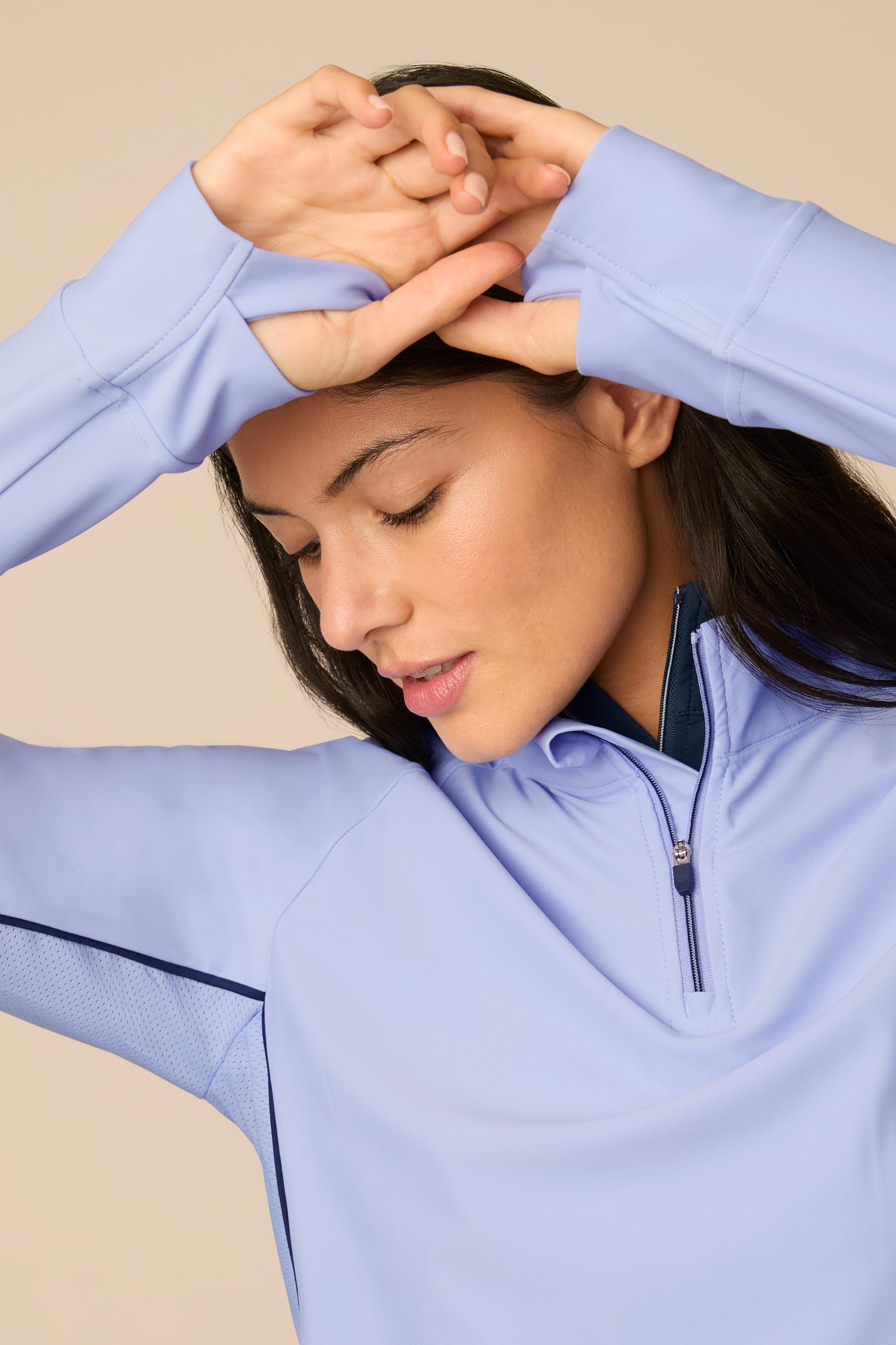 Woman wearing a Stardust half-zip pullover with a beige background