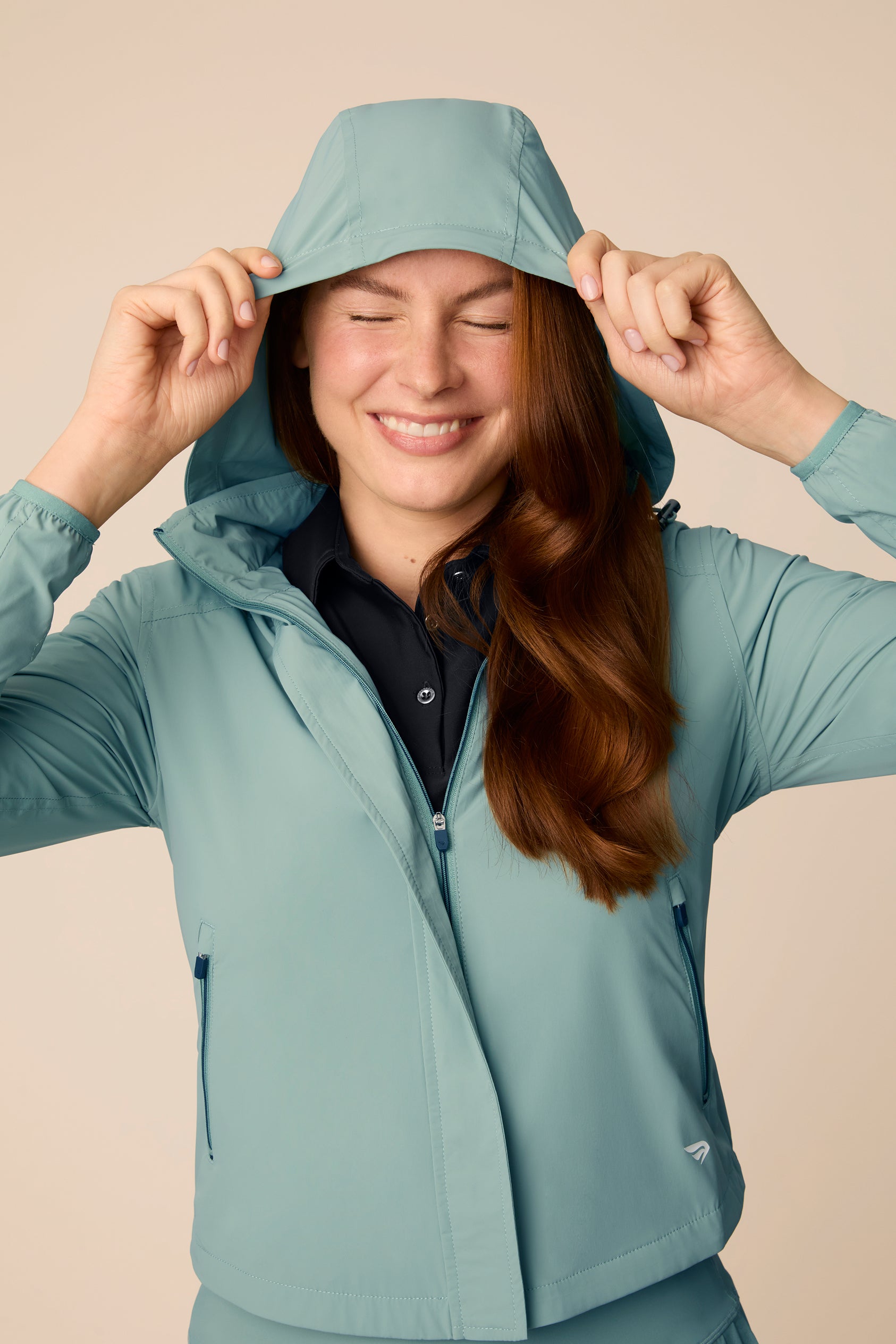 Meadow Haze | Model wearing a hooded Meadow Haze color windbreaker with white pleated skort.