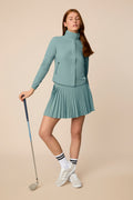 Meadow Haze | Model wearing a hooded Meadow Haze Gabrielle windbreaker with pleated skort.