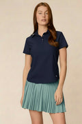 Midnight | Woman wearing the Midnight colored Lexi Polo and skort on a beige background