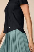 Meadow Haze | Woman wearing a Meadow Haze colored Michelle pleated skort on a beige background