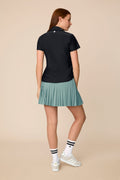 Meadow Haze | Woman wearing a Meadow Haze colored Michelle pleated skort on a beige background