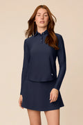 Midnight | Woman wearing The Ella Long Sleeve Polo on a beige background