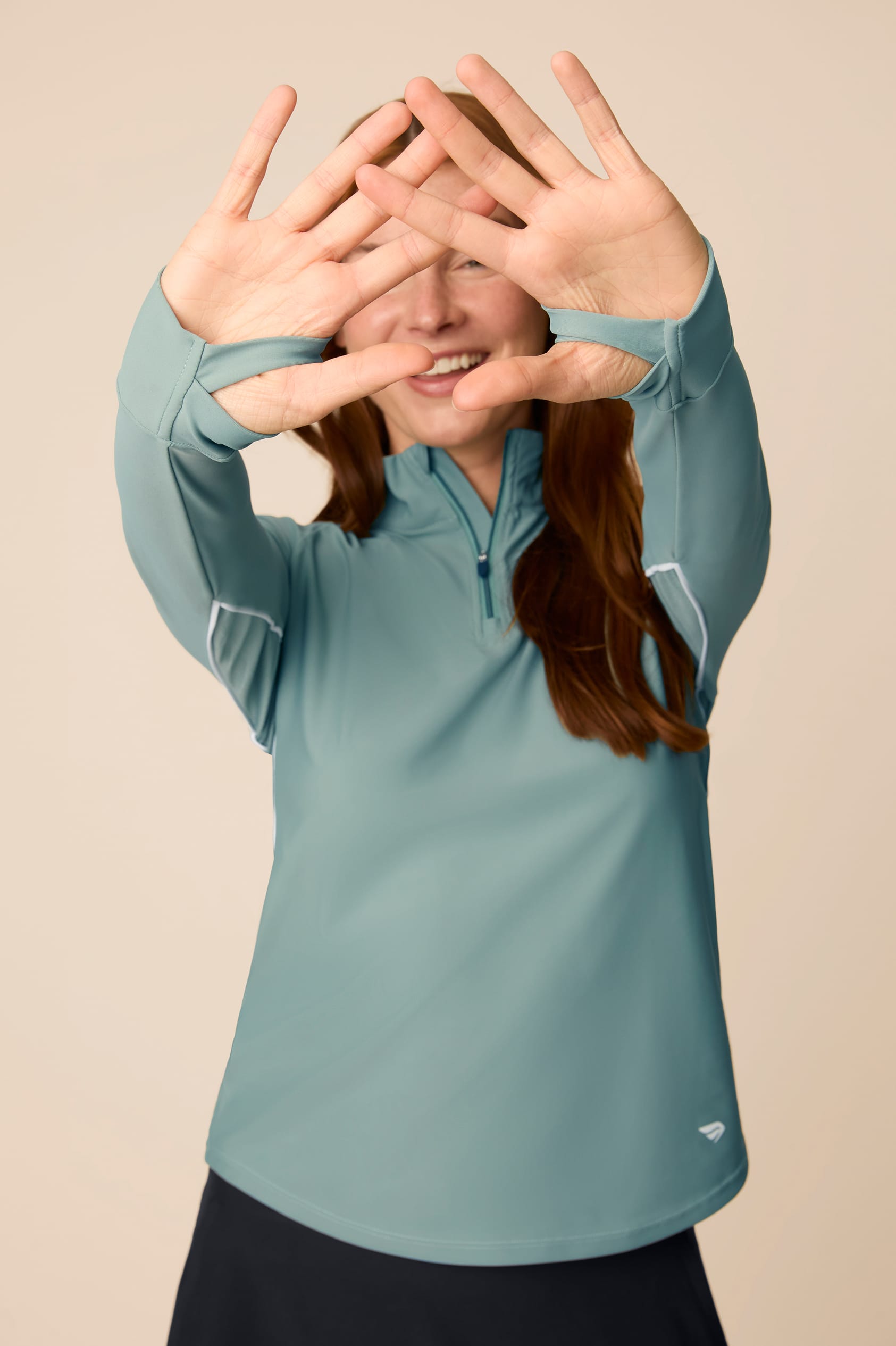Meadow Haze | Woman wearing a Meadow Haze Taylor Long-Sleeve Half-Zip and skort on a beige background