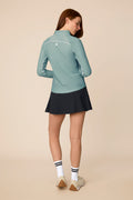 Meadow Haze | Woman wearing a Meadow Haze Taylor Long-Sleeve Half-Zip and skort on a beige background