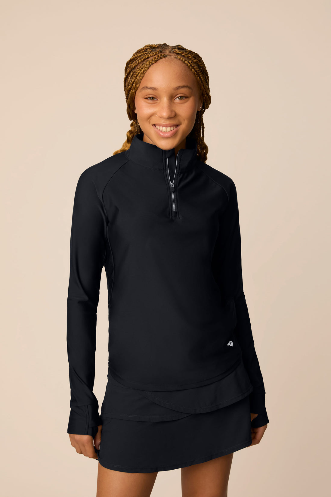 Midnight | Junior golfer in a Midnight color quarter-zip long sleeve shirt on a beige background