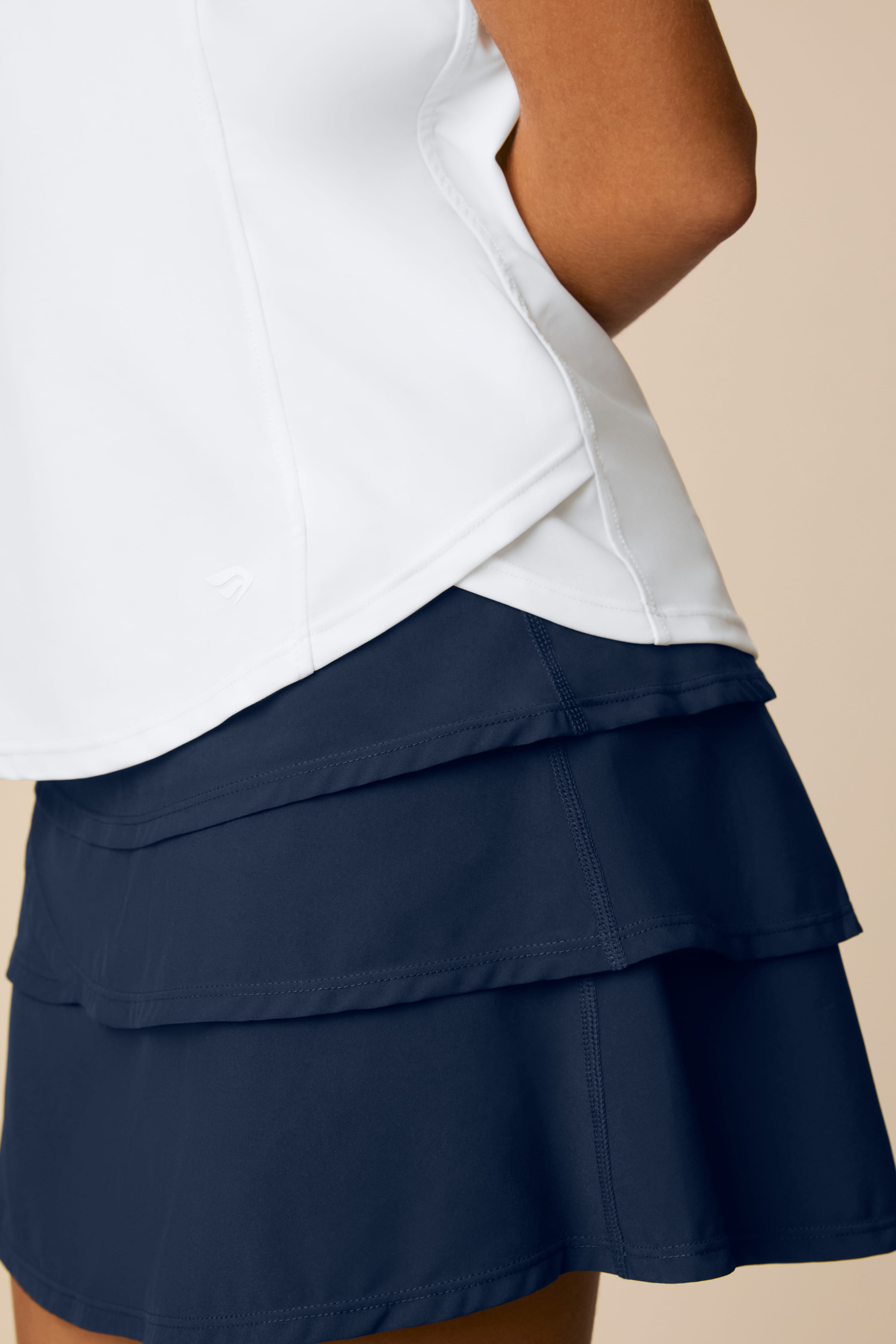 Midnight | Person wearing a Midnight colored skort on a beige background