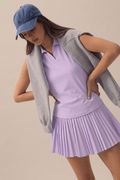 Lilac | Model wearing a denim cap, lilac skort and lilac top.