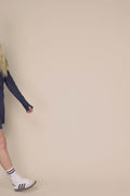 Midnight | Woman wearing The Ella Long Sleeve Polo on a beige background