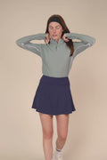 Meadow Haze | Woman wearing a Meadow Haze Taylor Long-Sleeve Half-Zip and skort on a beige background